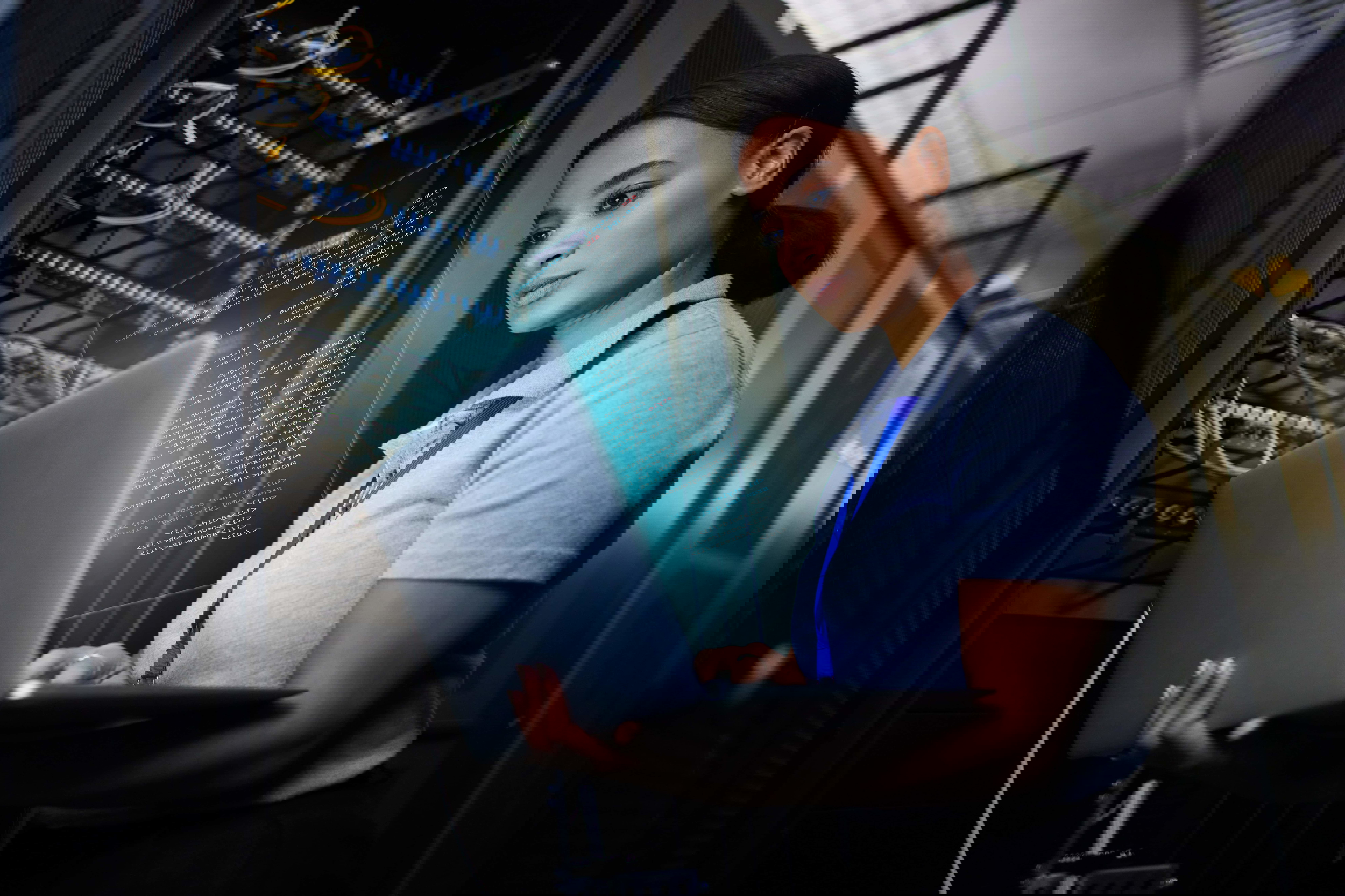 Woman with laptop in server room representing world-class education and talent pipeline